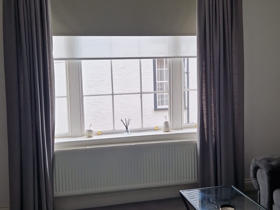 Living room with large window and curtains at The Escape Weymouth