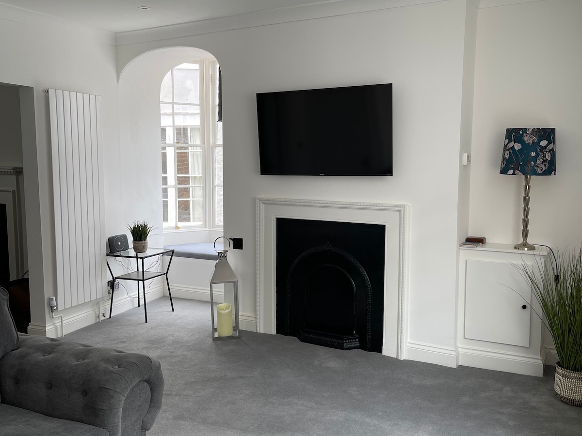 Spacious living room with fireplace, Smart TV and arched window at The Escape