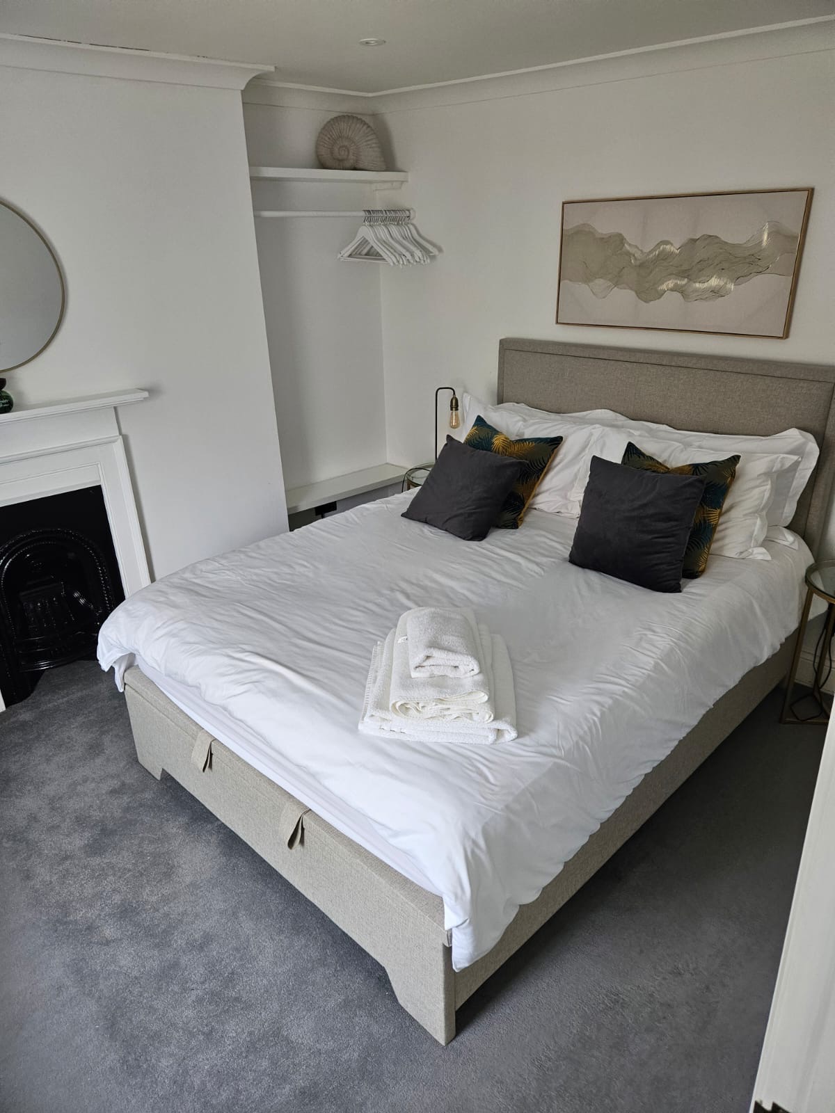 Bedroom with original fireplace, mirror and king bed at The Escape Weymouth