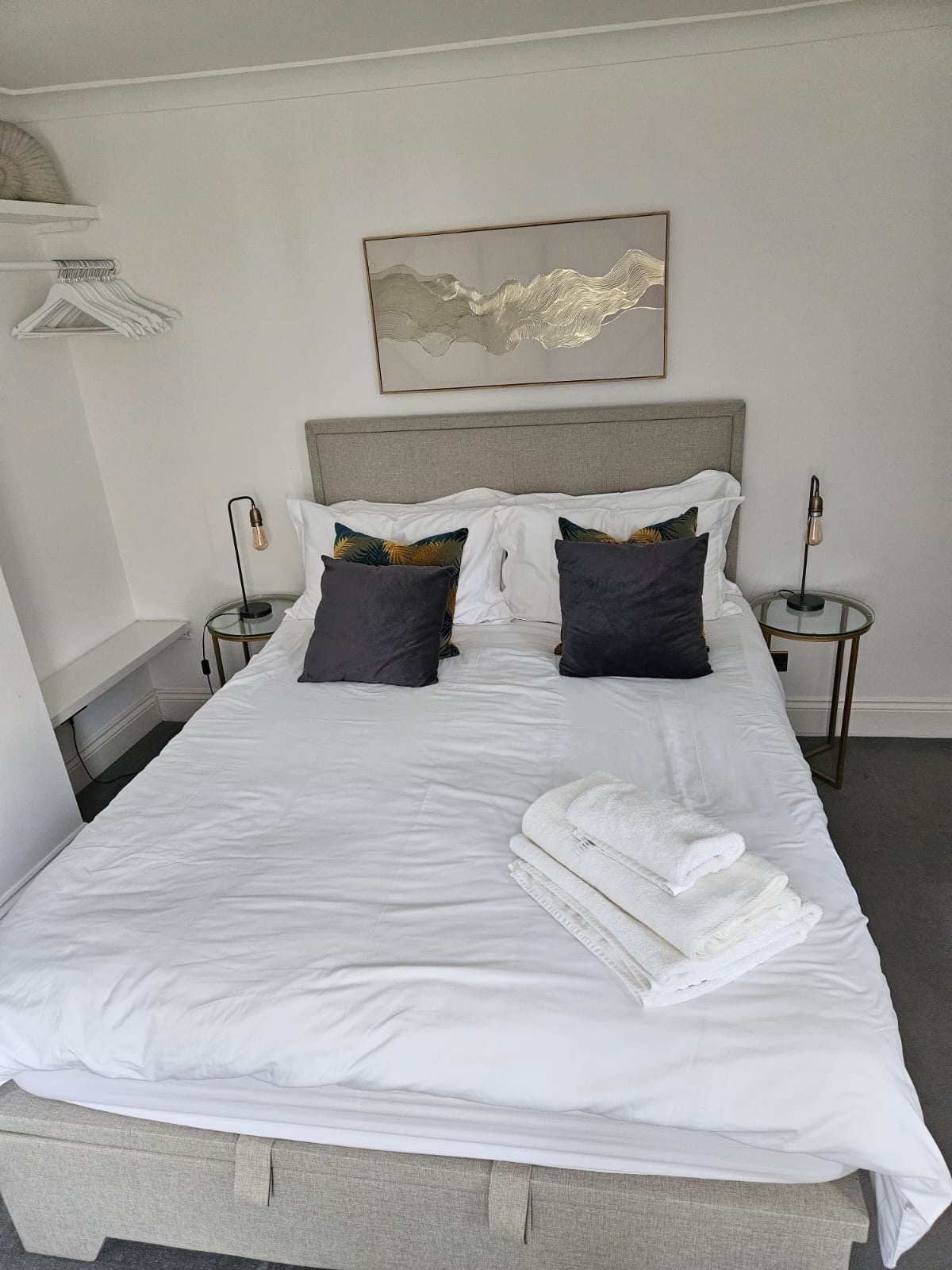 King size bed with fresh towels and bedside lamps at The Escape Weymouth