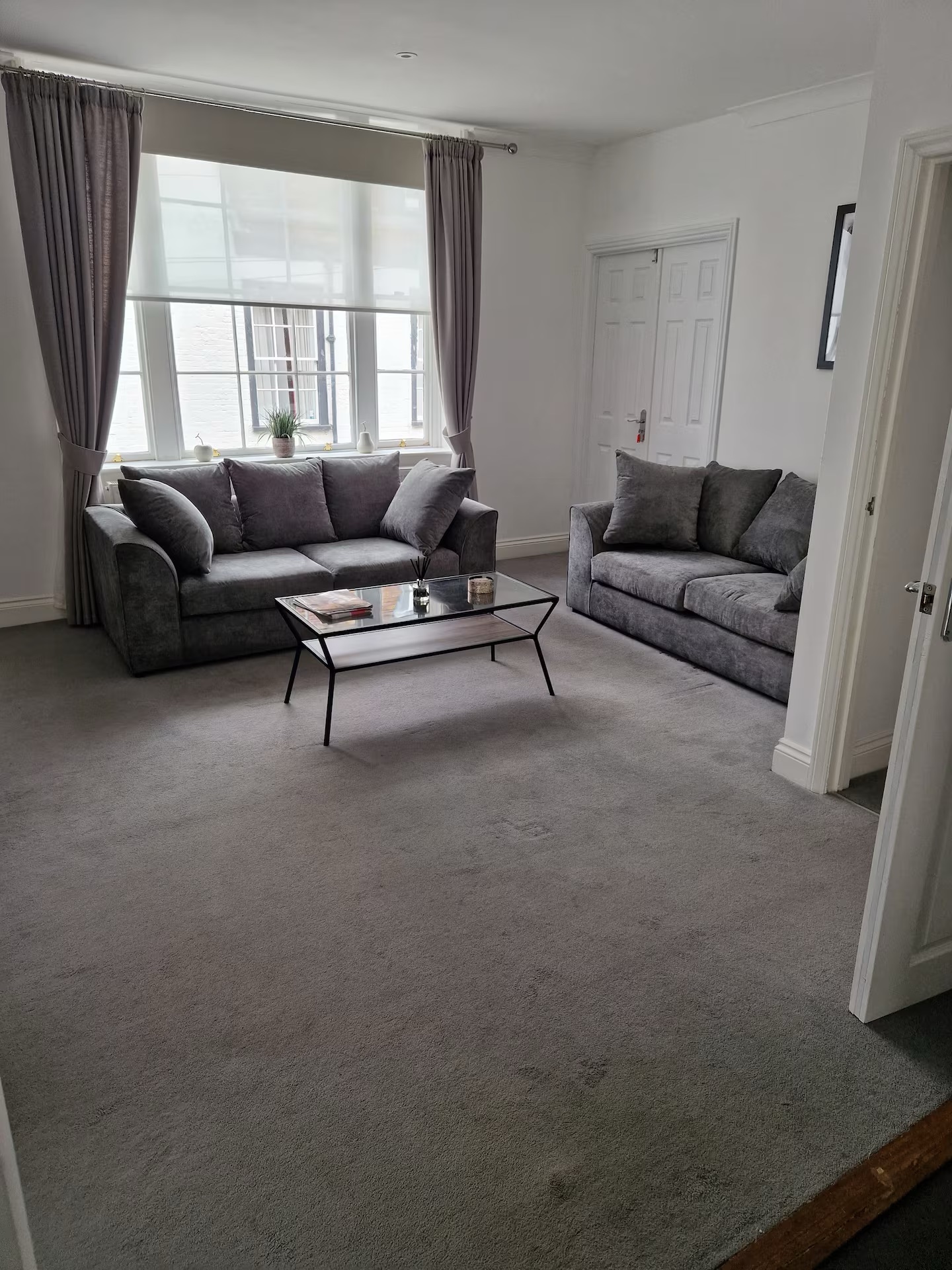 Living room with grey sofas and coffee table at The Escape Weymouth